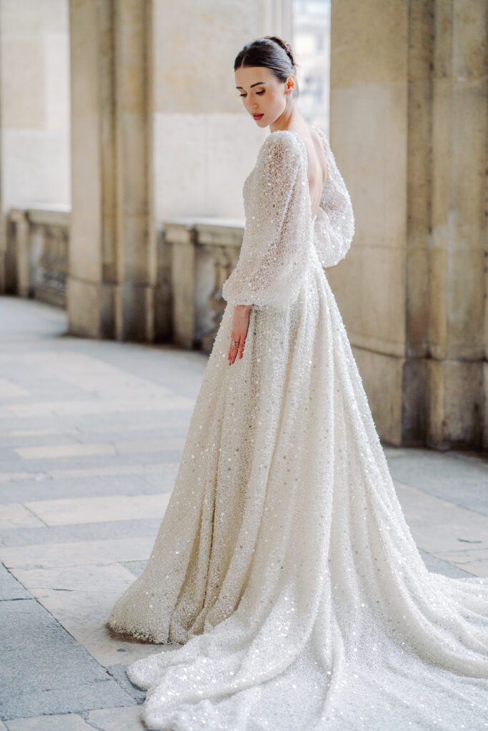 Paris pre-wedding session at the Louvre with bride in a sequined gown with a full train, long sleeved, deep plunging neckline and back, photographed by Italy destination photographer